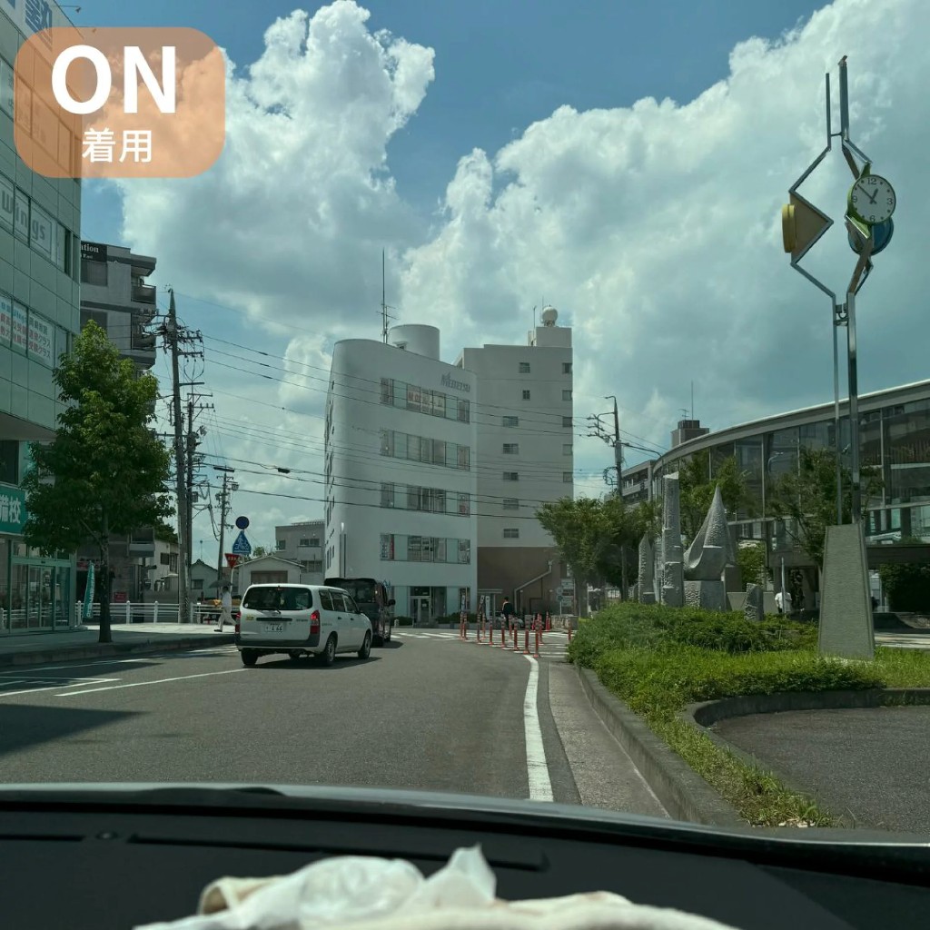 運転席からの眺め。反射が抑えられ、青空や建物がはっきり見えるイメージ（着用）